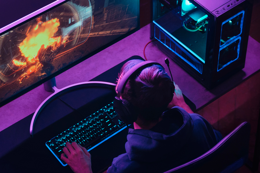 Boy gaming on PC with RGB purple lighting. DDR5